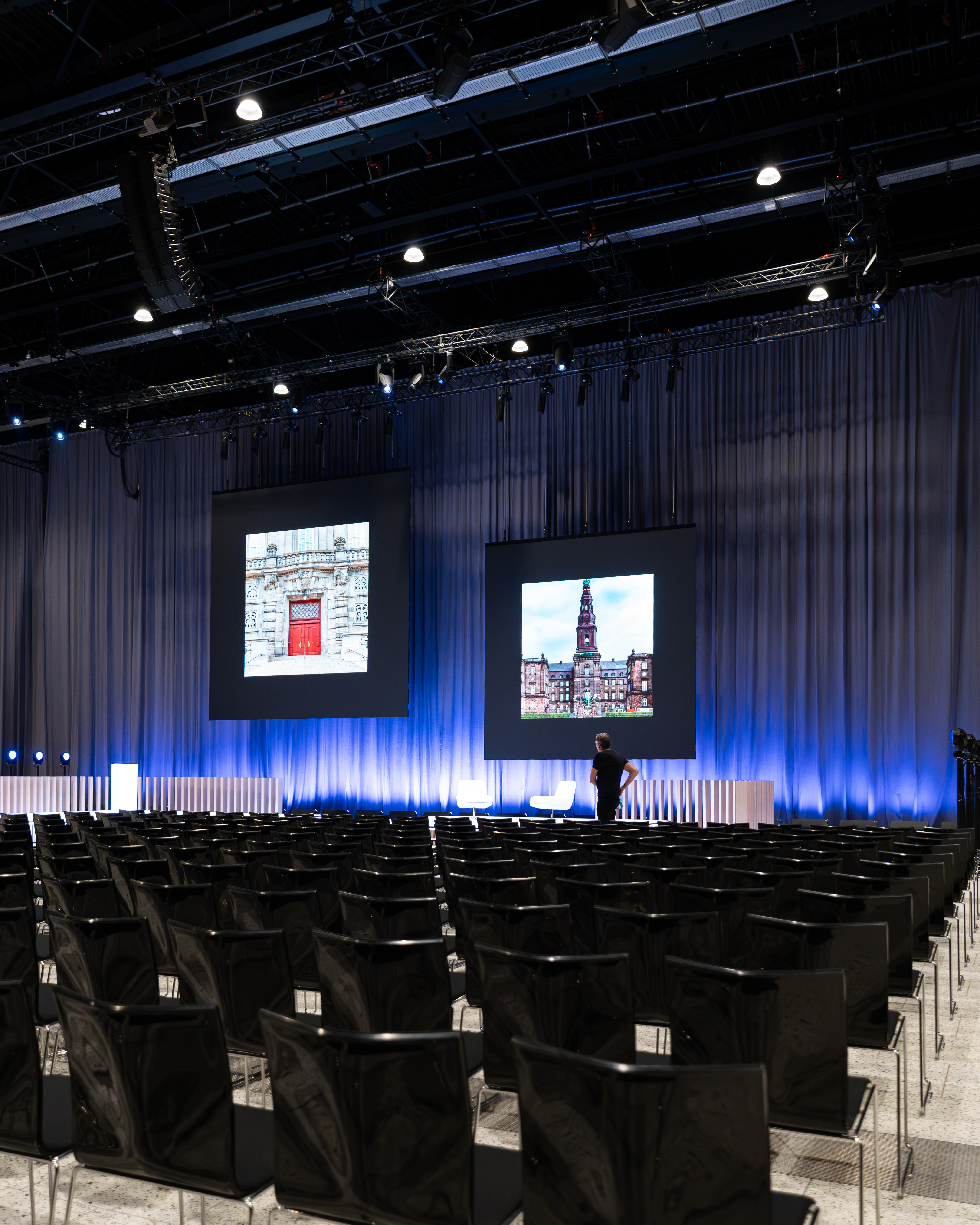Konferencescene med storeskærme og præsentation i Bella Center.