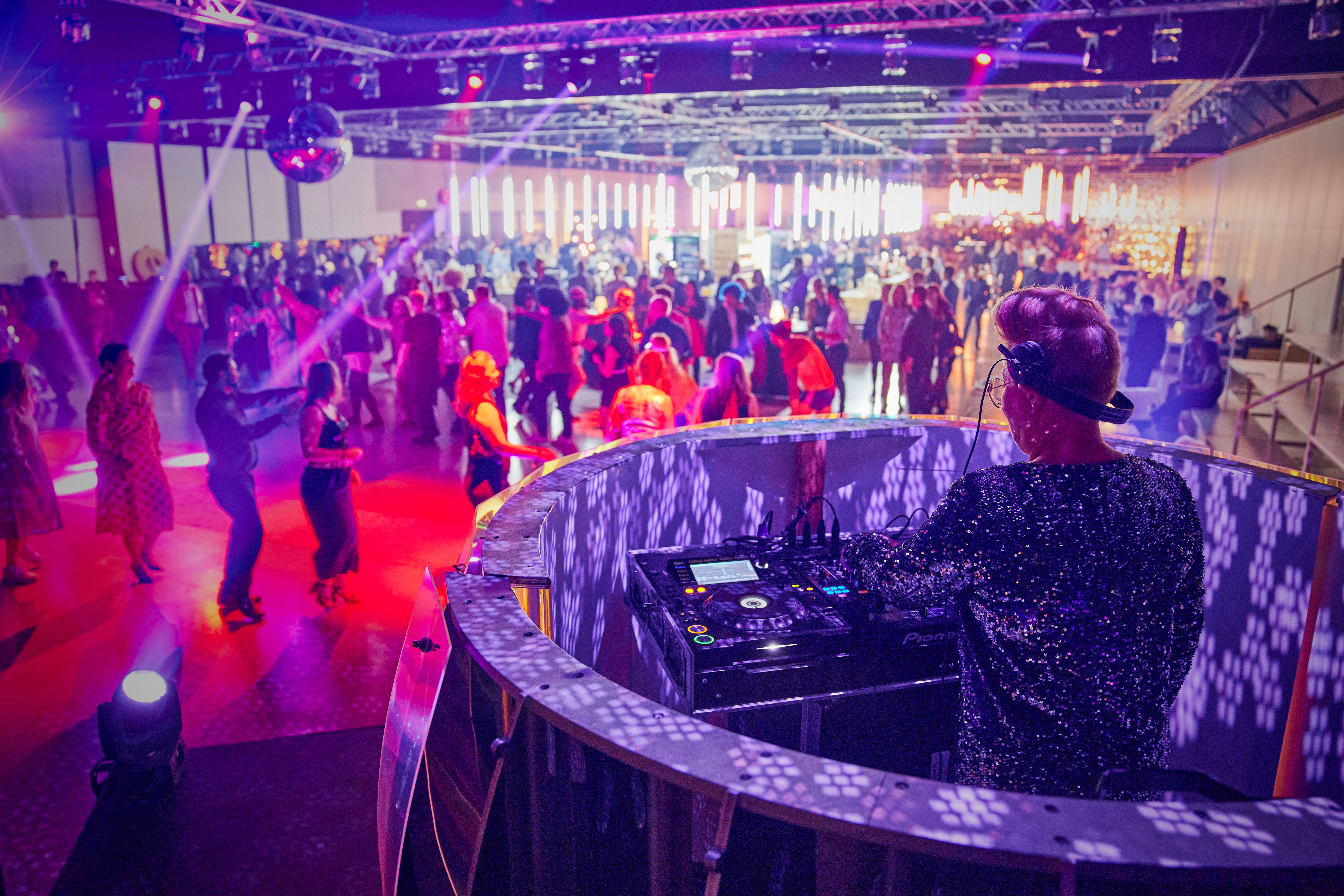 DJ spiller for fyldt dansegulv med farverig lyssætning til julefrokost i Bella Center.