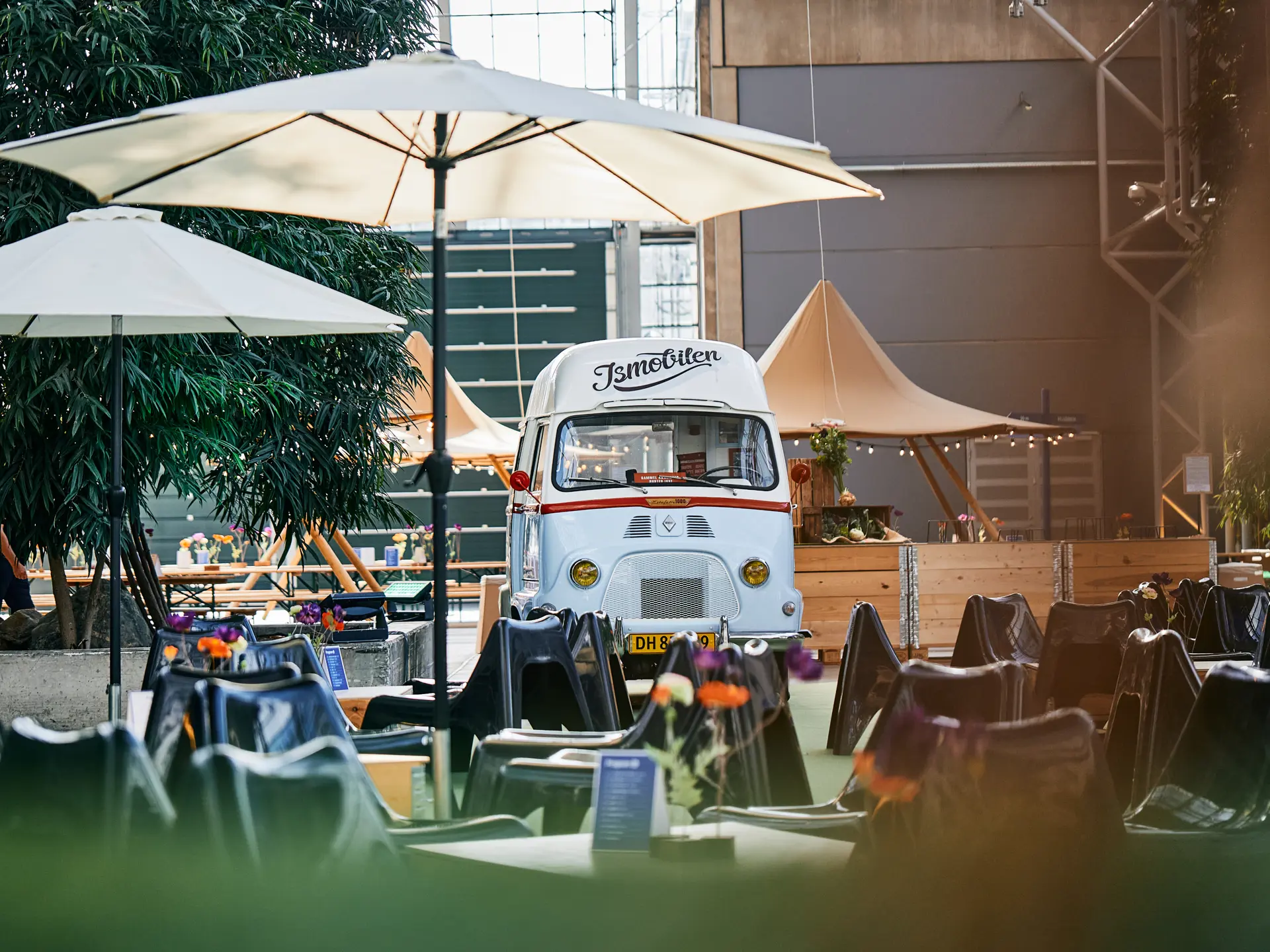 Vintage isbil i Hal E i Bella Center omgivet af caféborde, parasoller og blomster, skaber hyggelig stemning til event eller messe