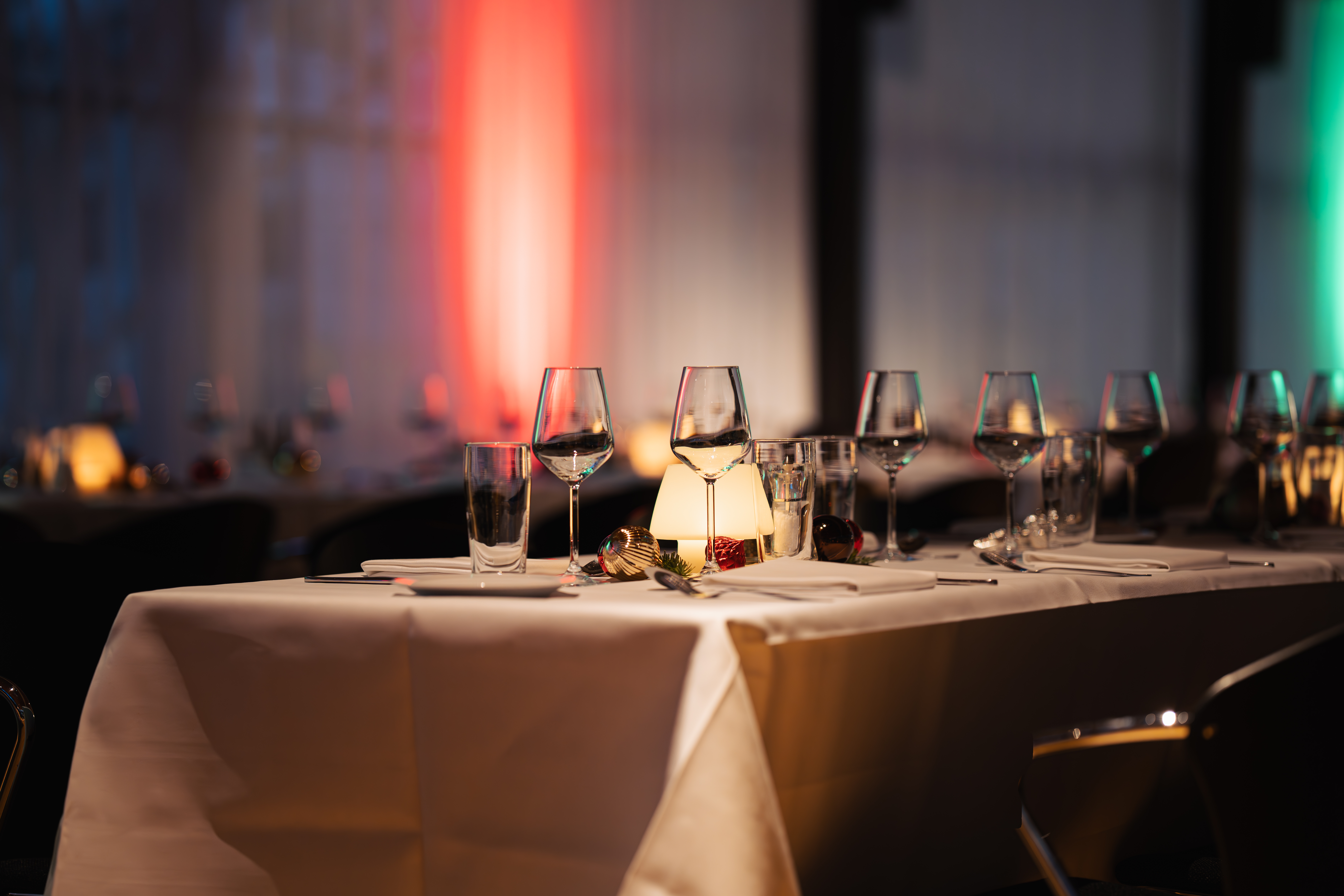 Stemningsfuldt bord med glas, stearinlys og julepynt til julefrokost i Bella Center.