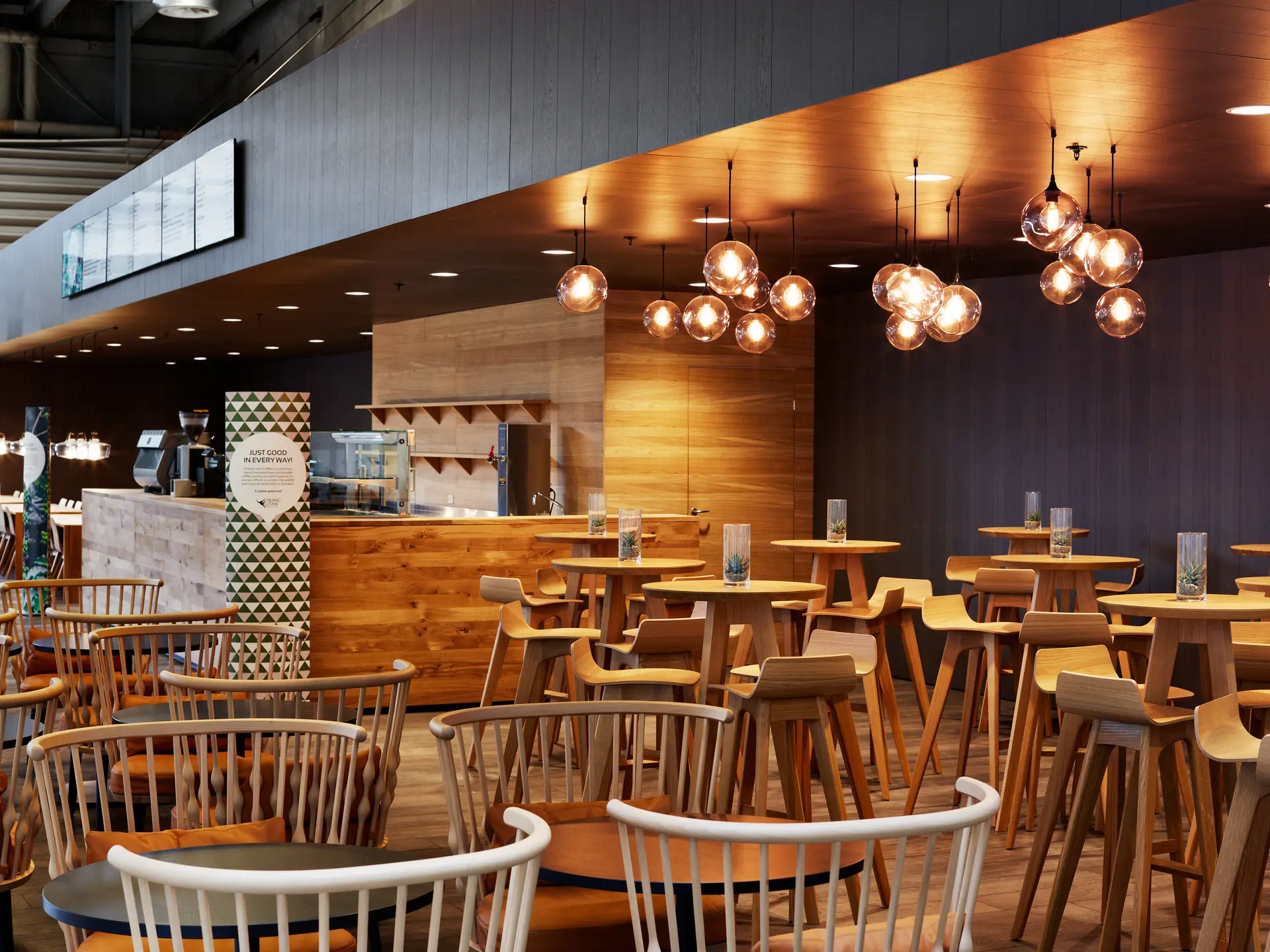 Orangu Lounge – caféområde med højborde, barstole og dekorative loftslamper i klynger.