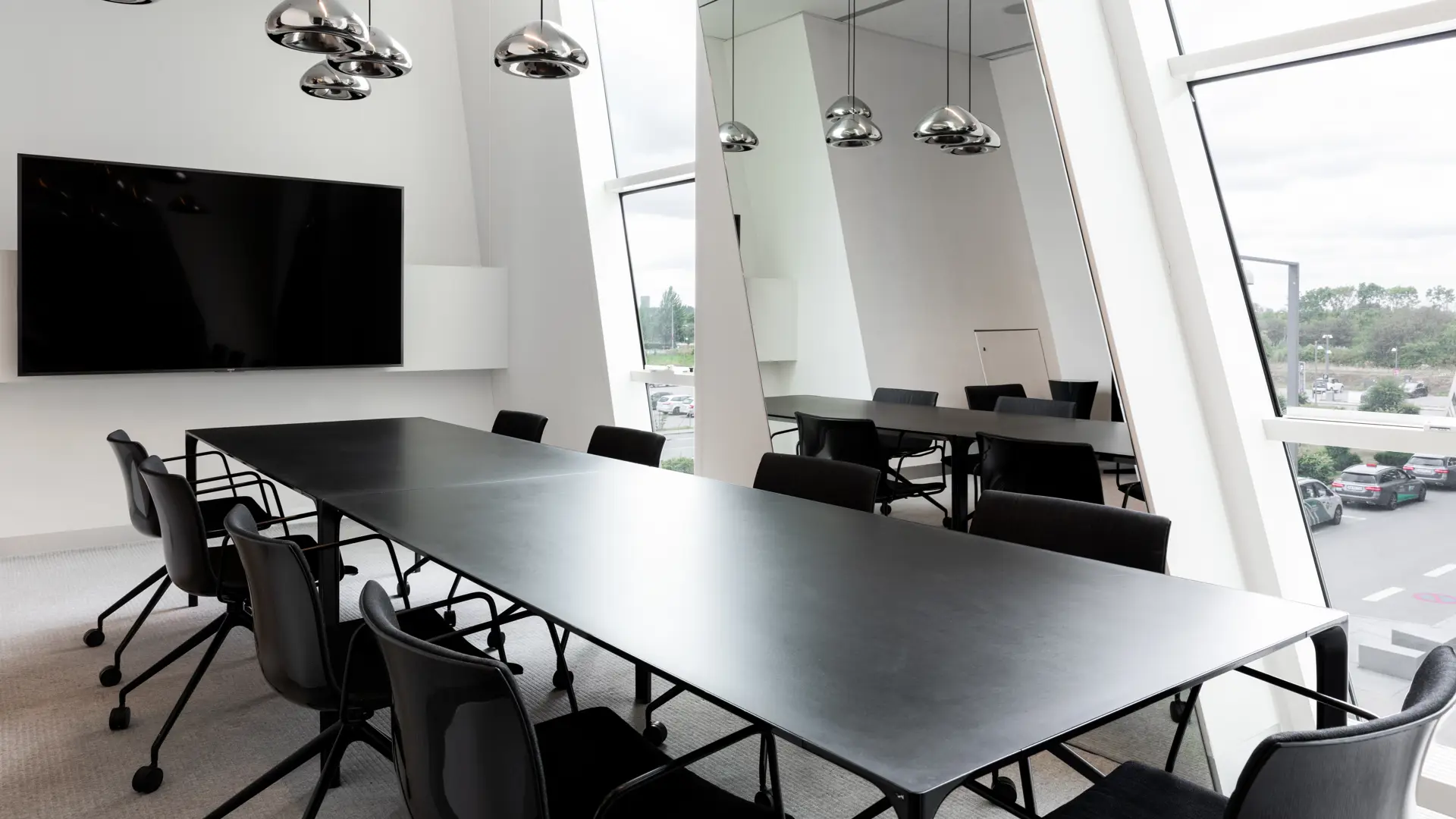 Moderne mødelokale med langbord og skærm på AC Hotel Bella Sky – velegnet til mindre møder og VIP-sessions.