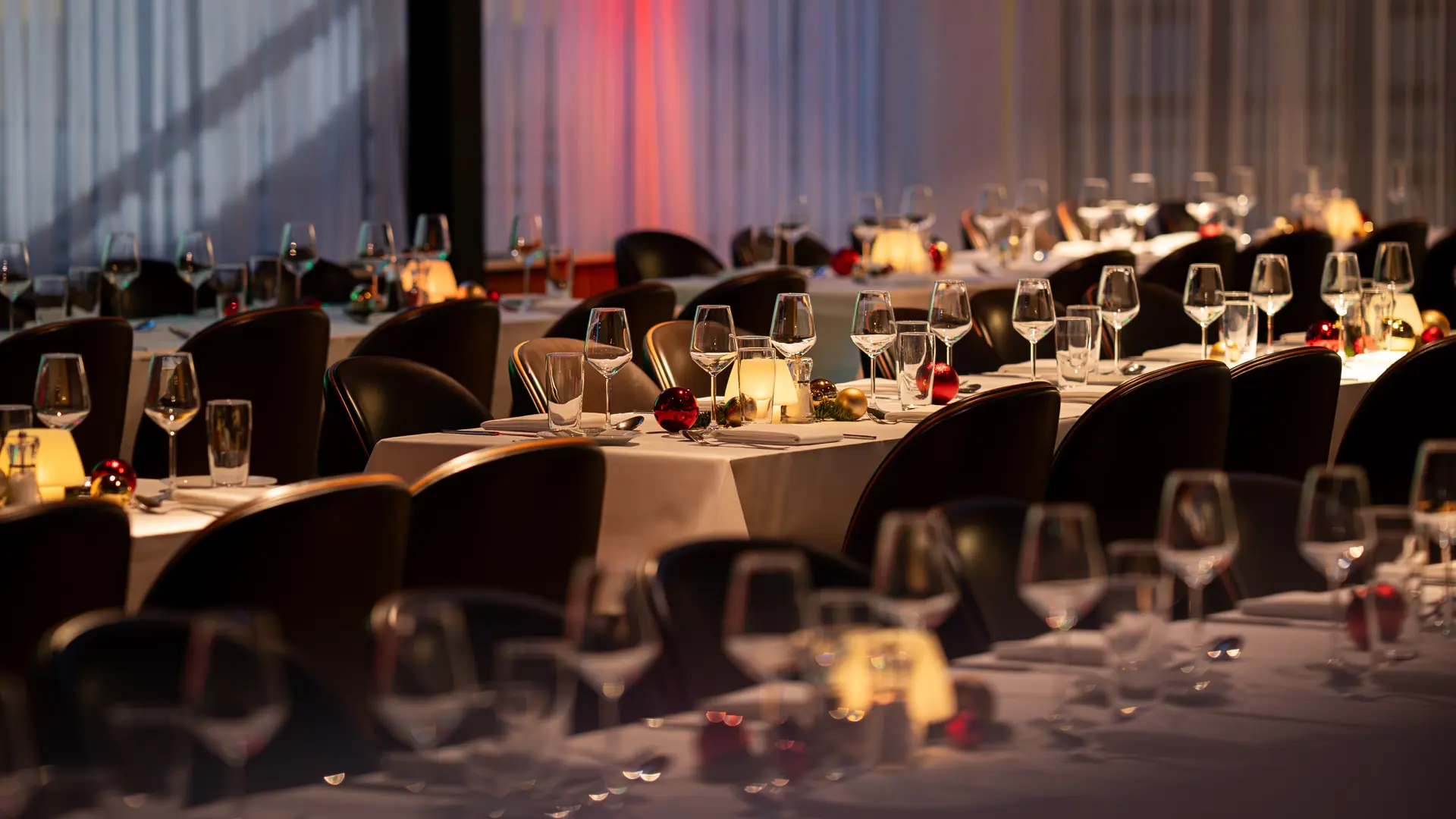 Langbord dækket op til julefrokost i Bella Center med glas, servietter og festlig belysning – klar til både små og store selskaber.