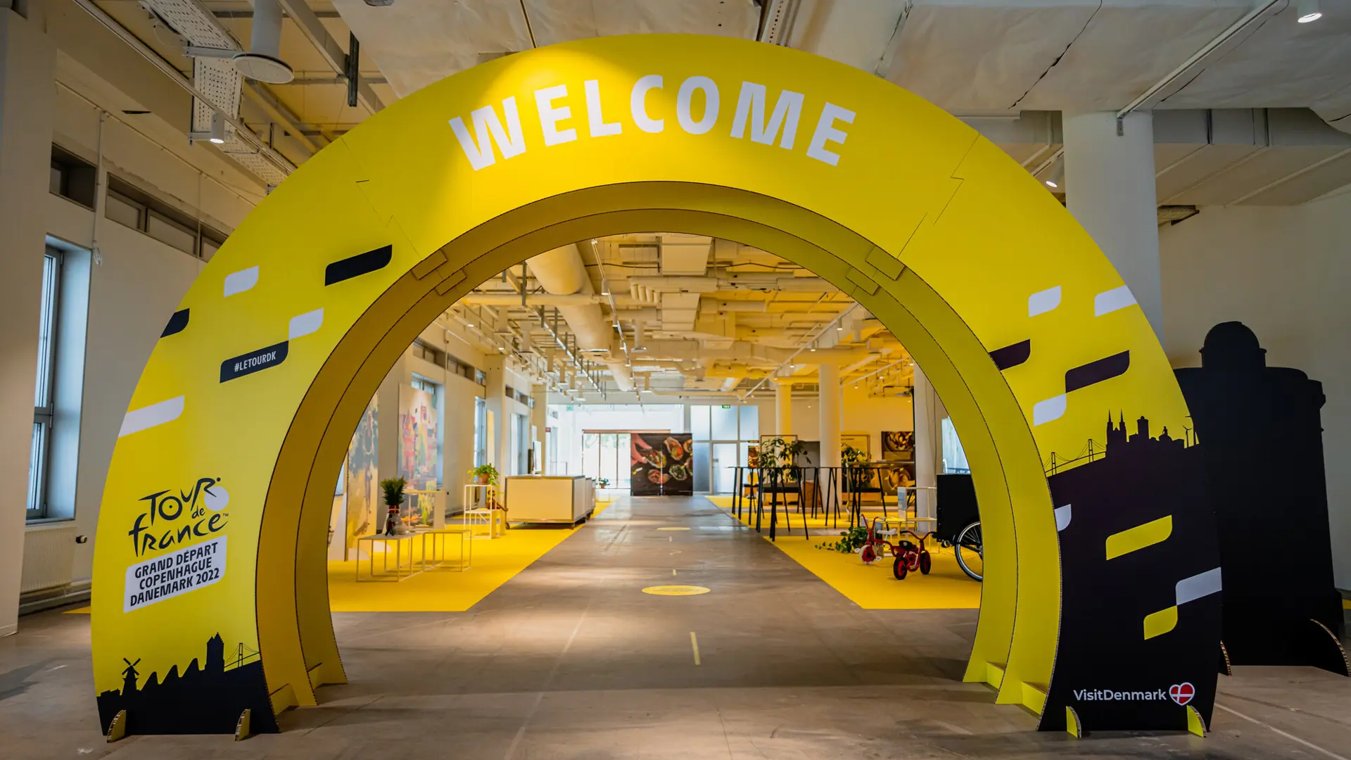 Gult Tour de France velkomst-setup i Hal B i Bella Center med industrielt design og plads til events, konferencer og messer