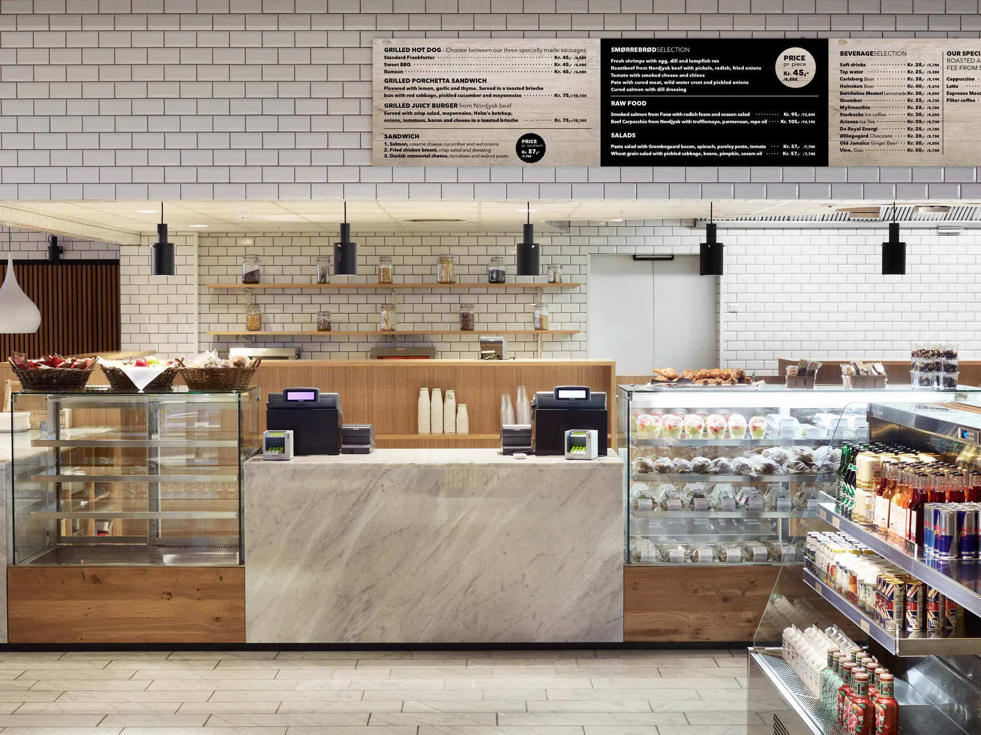 The Gastro – frontdisk med marmordetaljer, glasmontrer fyldt med friskbagte brød, sandwiches og kolde drikke.