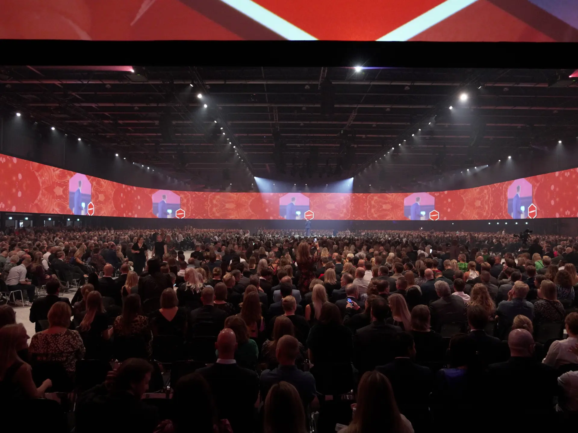 Konferenceopsætning i Hal D, Bella Arena med langborde og storskærm.