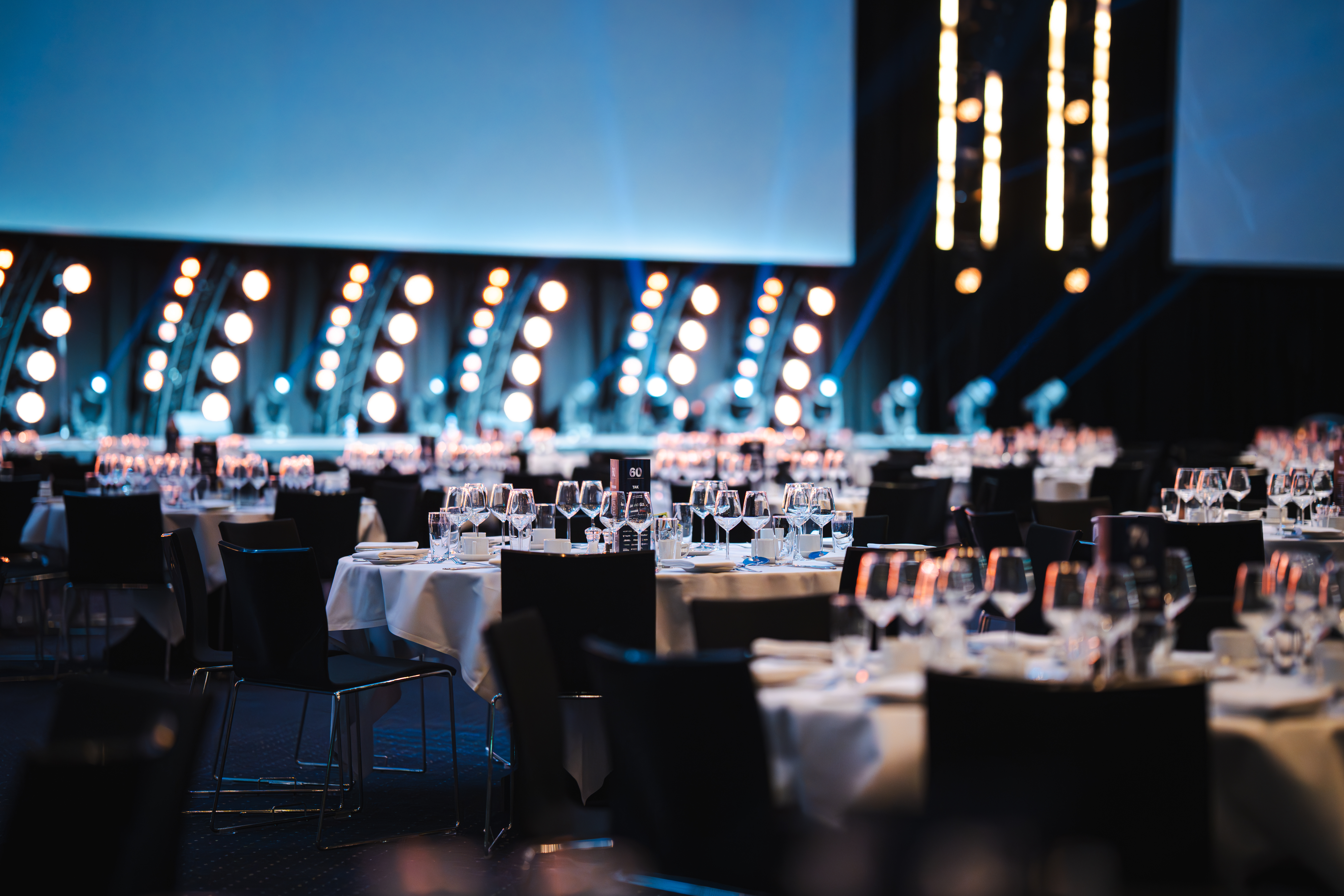 Hal A i Bella Center med opdækkede runde borde til gallamiddag eller konference.