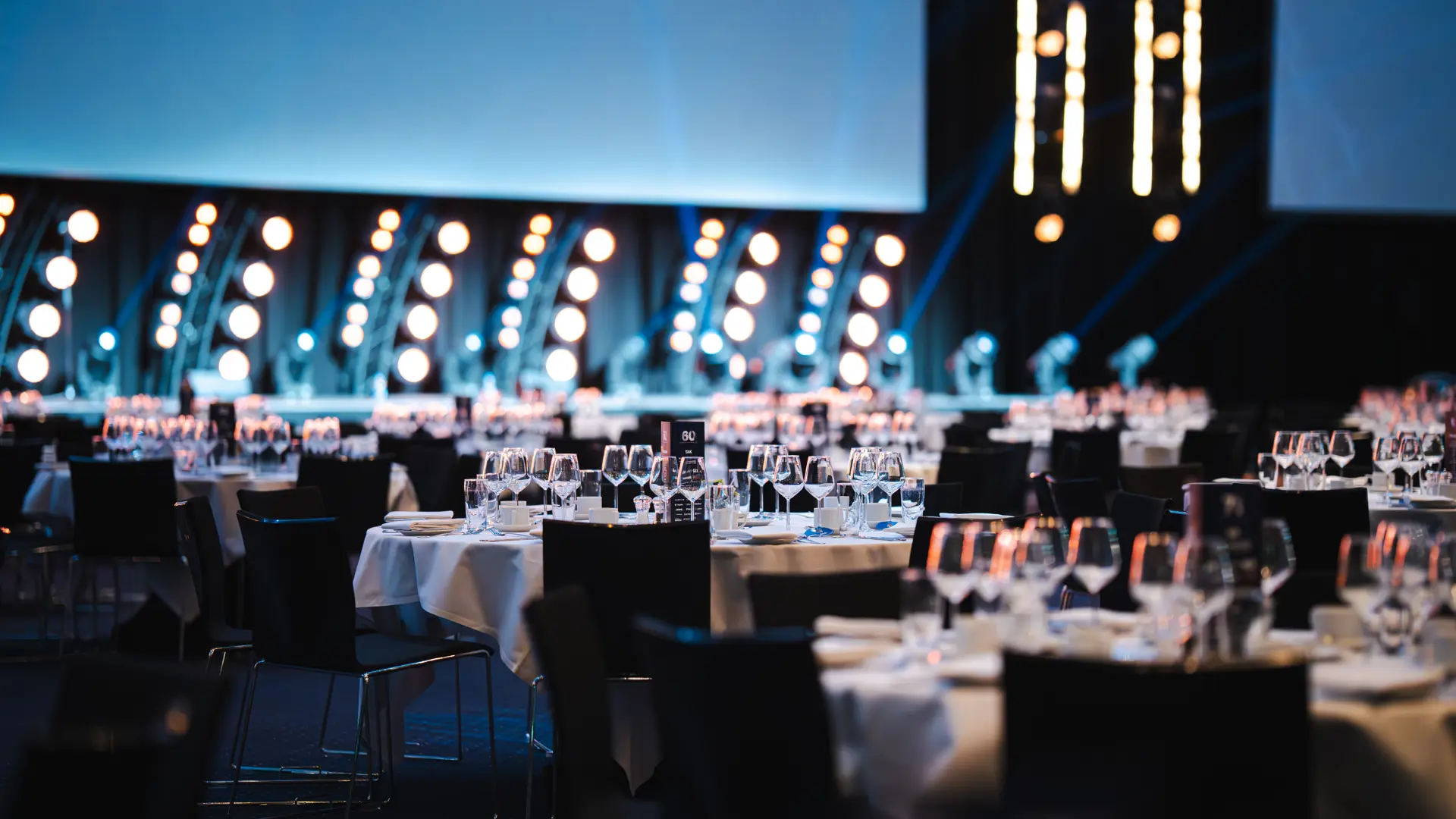 Hal A i Bella Center med opdækkede runde borde til gallamiddag eller konference.