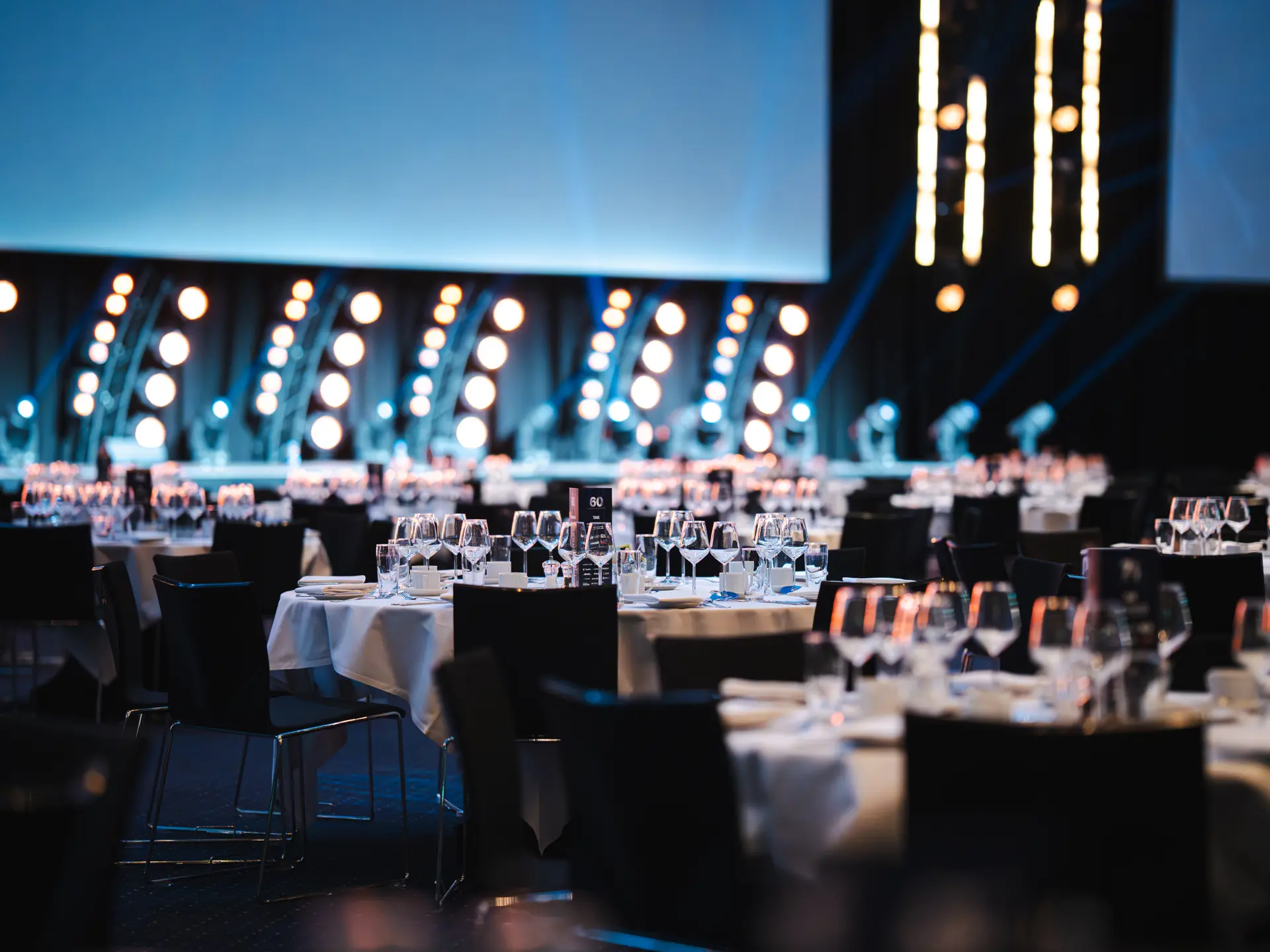 Hal A i Bella Center med opdækkede runde borde til gallamiddag eller konference.