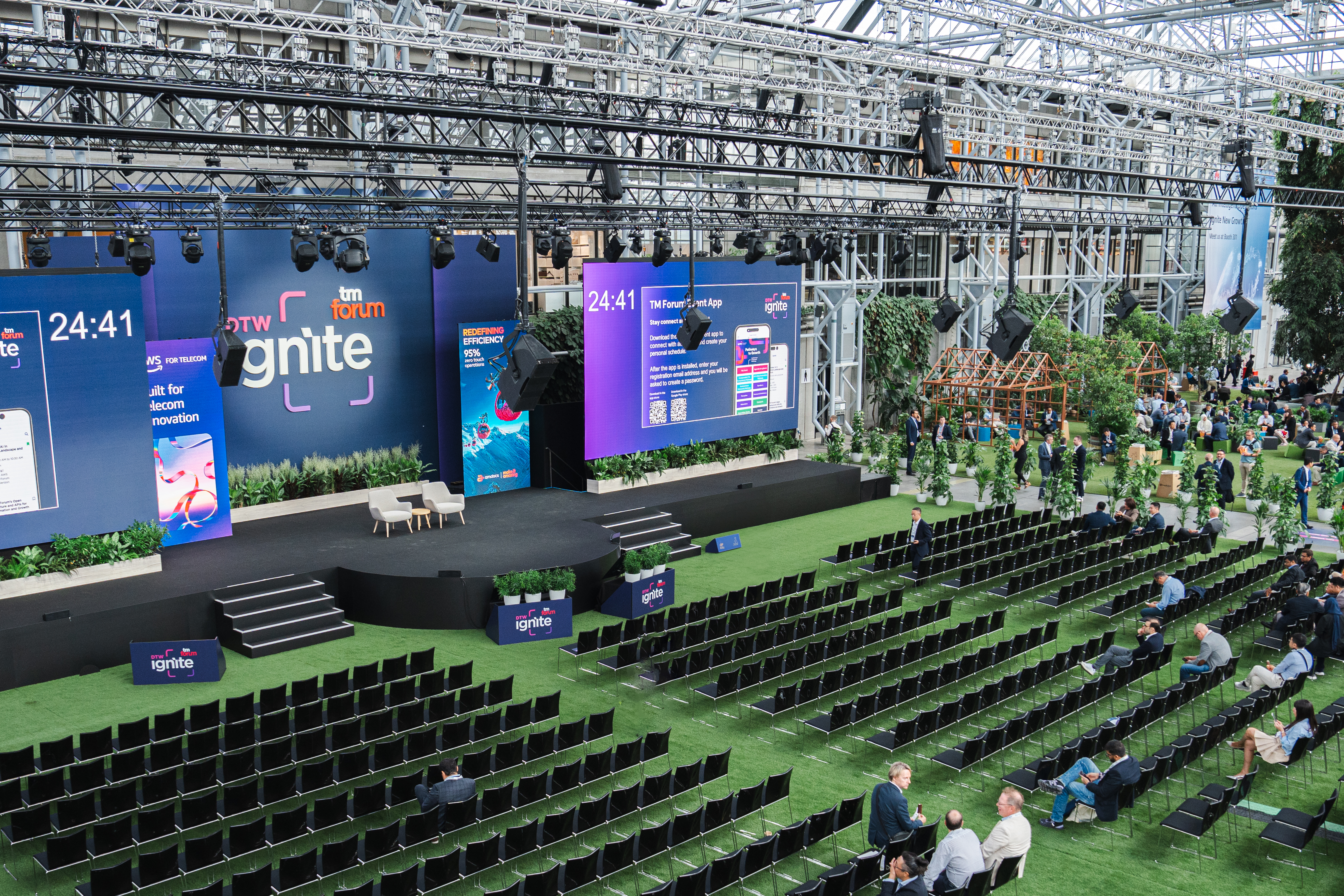 Stor konferenceopsætning med scene, LED-skærme og grønne omgivelser i Bella Center.