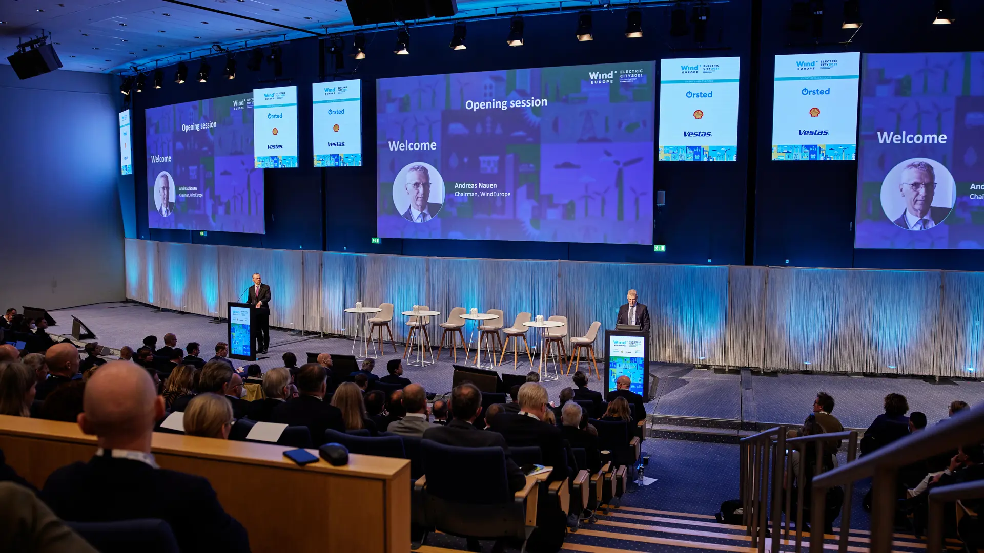 Paneldebat på scenen i Auditorium 10-12 med stort lærred under international kongres i Bella Center Copenhagen.
