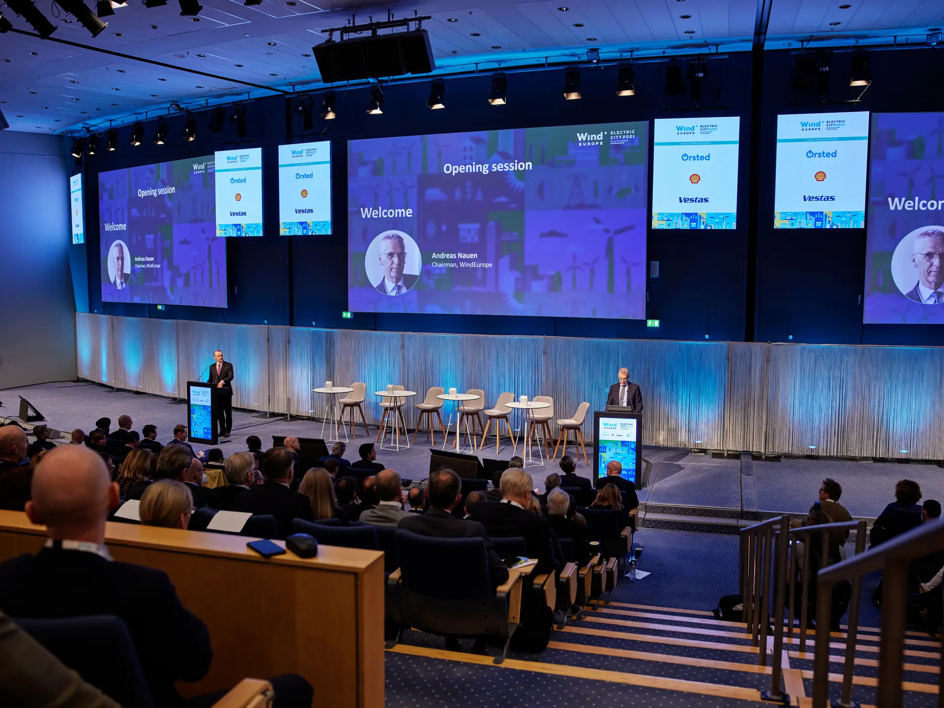 Paneldebat på scenen i Auditorium 10-12 med stort lærred under international kongres i Bella Center Copenhagen.