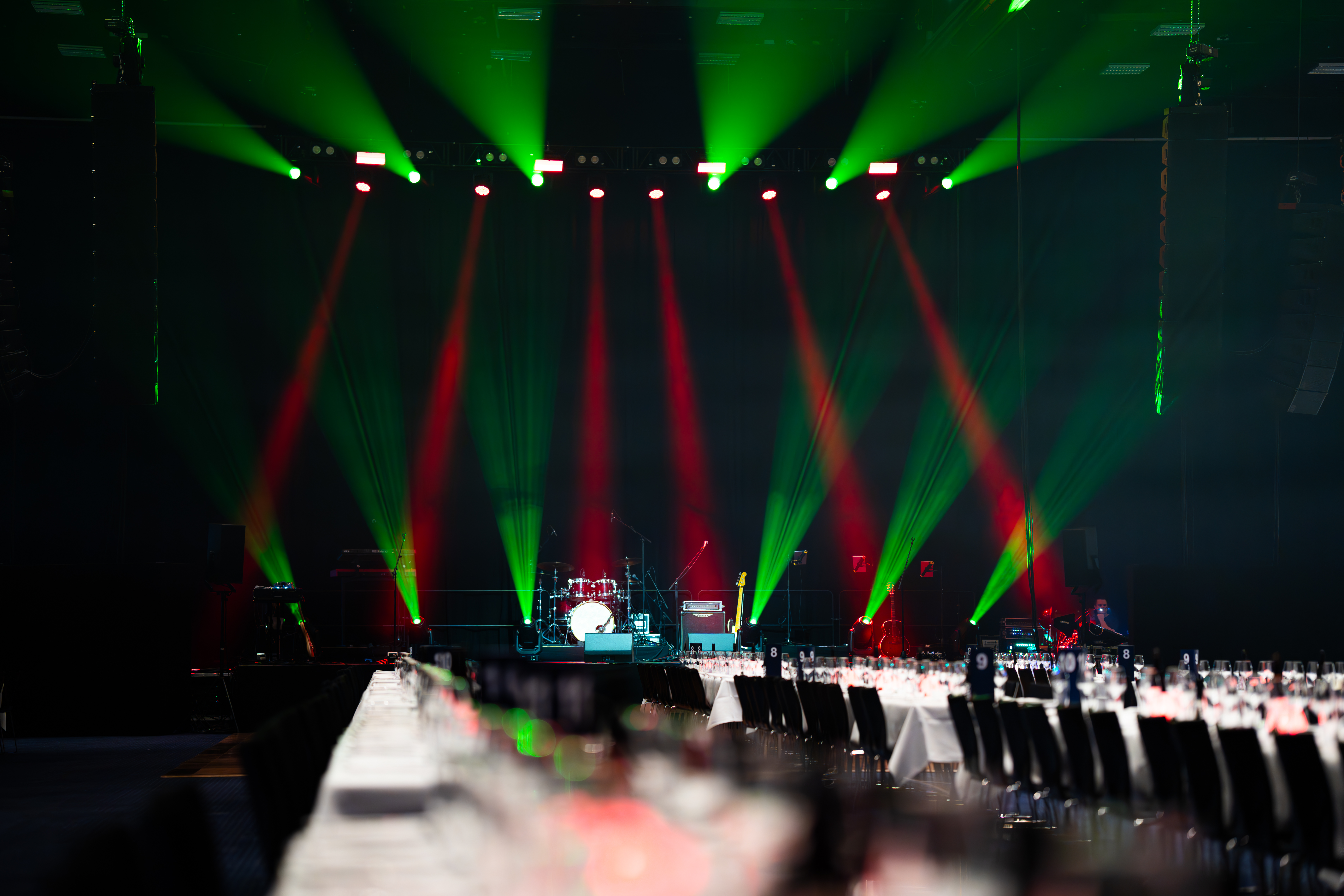 Hal A opstillet til koncert og fest med langborde, scenelys og instrumenter.