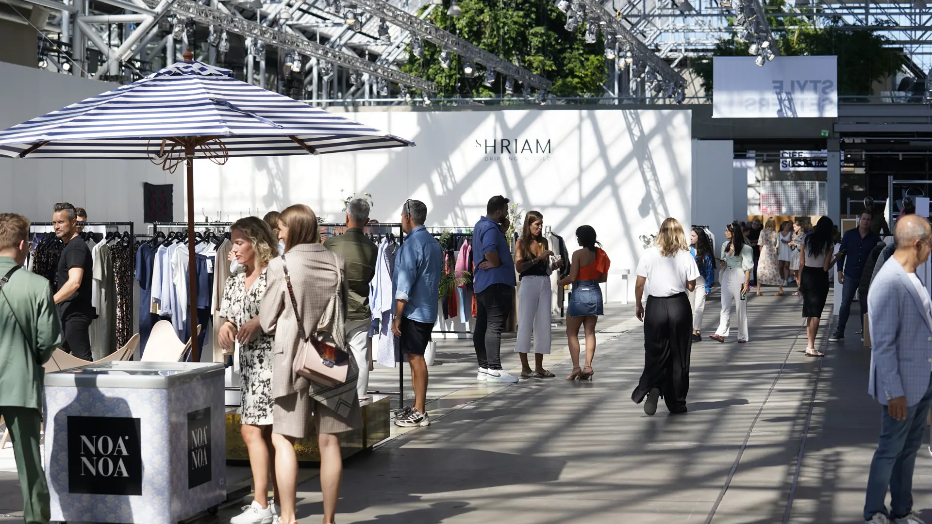Gæster og udstillere på modemesse i Bella Center Copenhagen med moderne stande og naturligt lys.