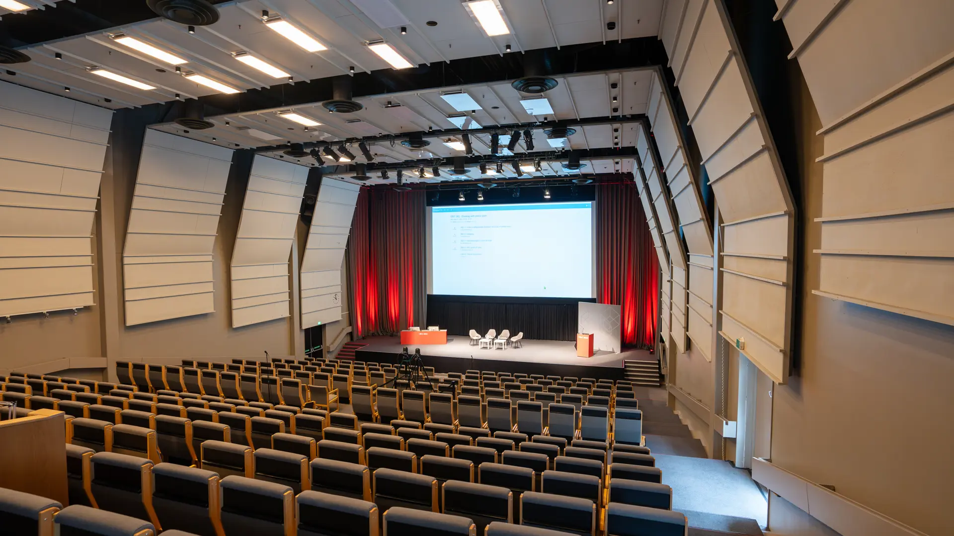 Kongres i Auditorium 15, Bella Center, København – moderne biograflignende stole med klapborde.