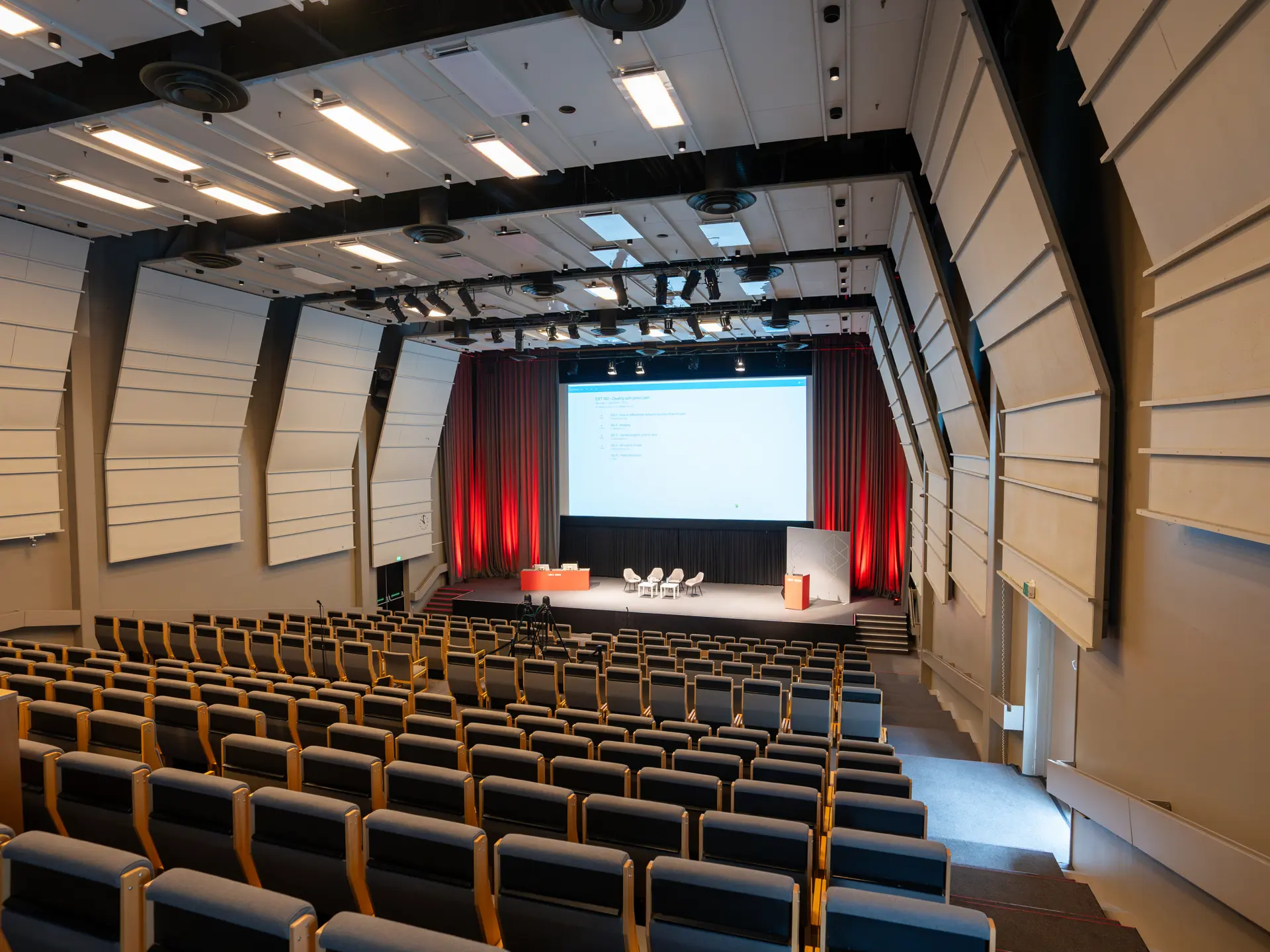 Kongres i Auditorium 15, Bella Center, København – moderne biograflignende stole med klapborde.