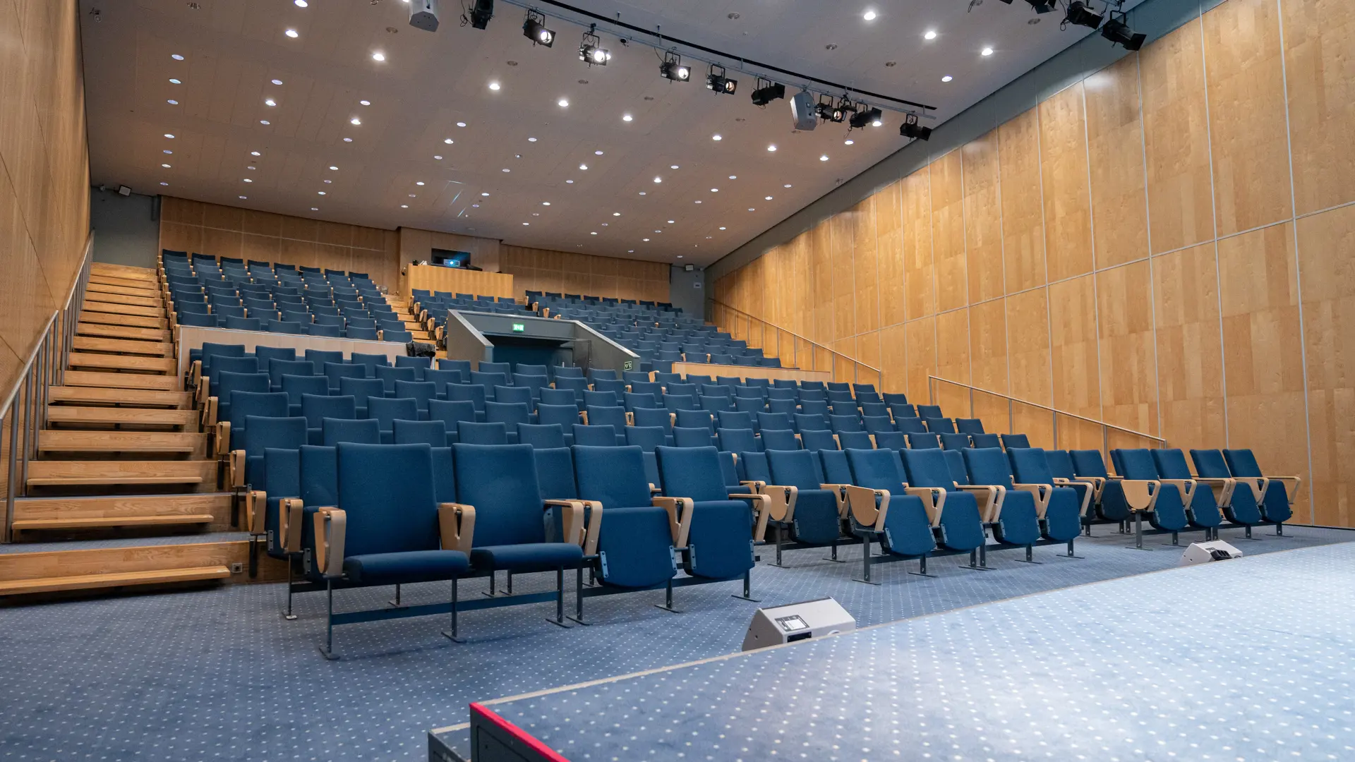 Tomt auditorium i Bella Center København med blå stolerækker, klar til kongres eller konference.