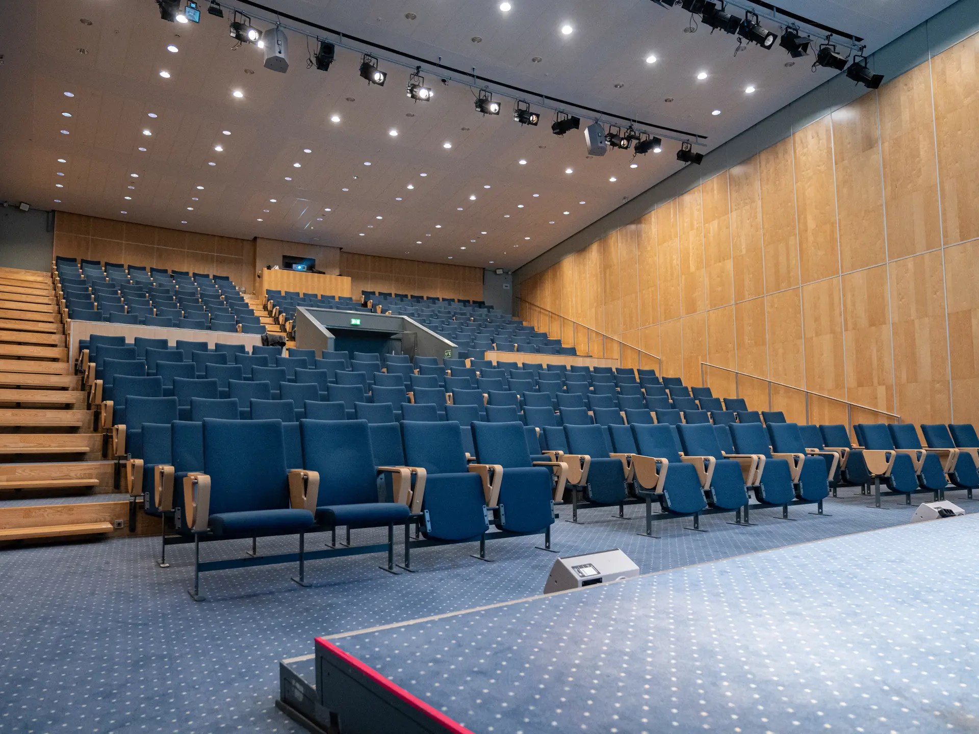 Tomt auditorium i Bella Center København med blå stolerækker, klar til kongres eller konference.