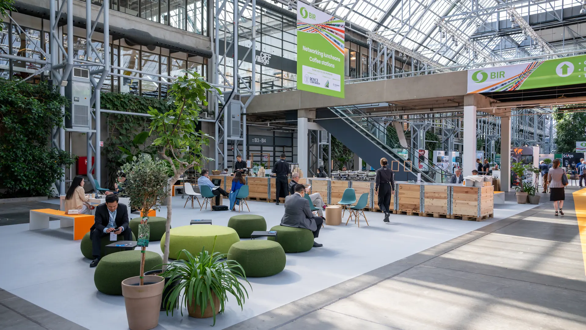 Netværksområde med lounge, planter og siddepladser i Hal E.