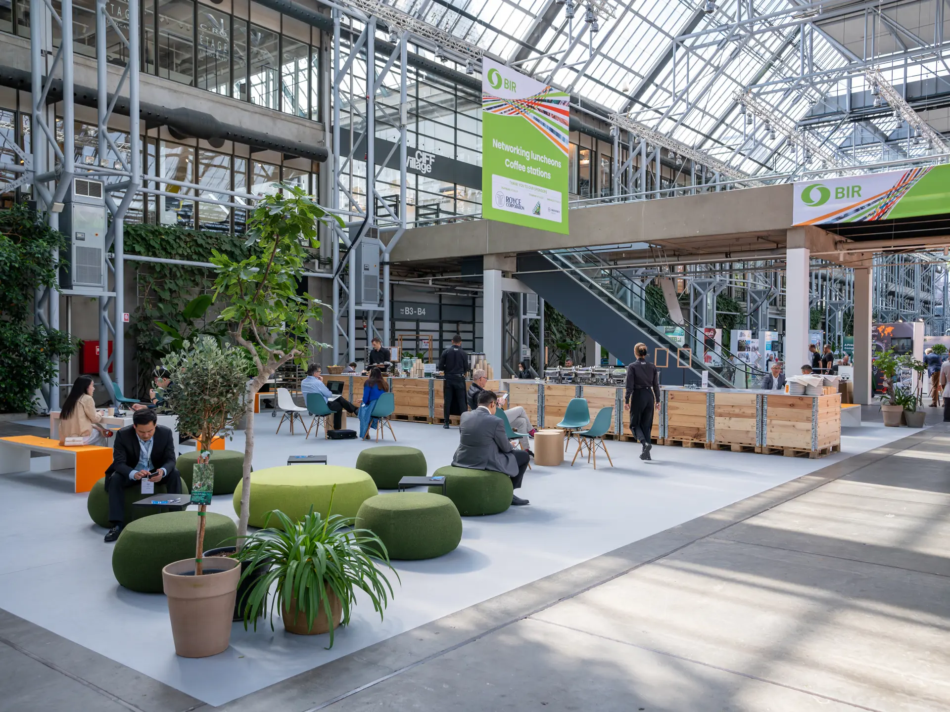 Netværksområde med lounge, planter og siddepladser i Hal E.