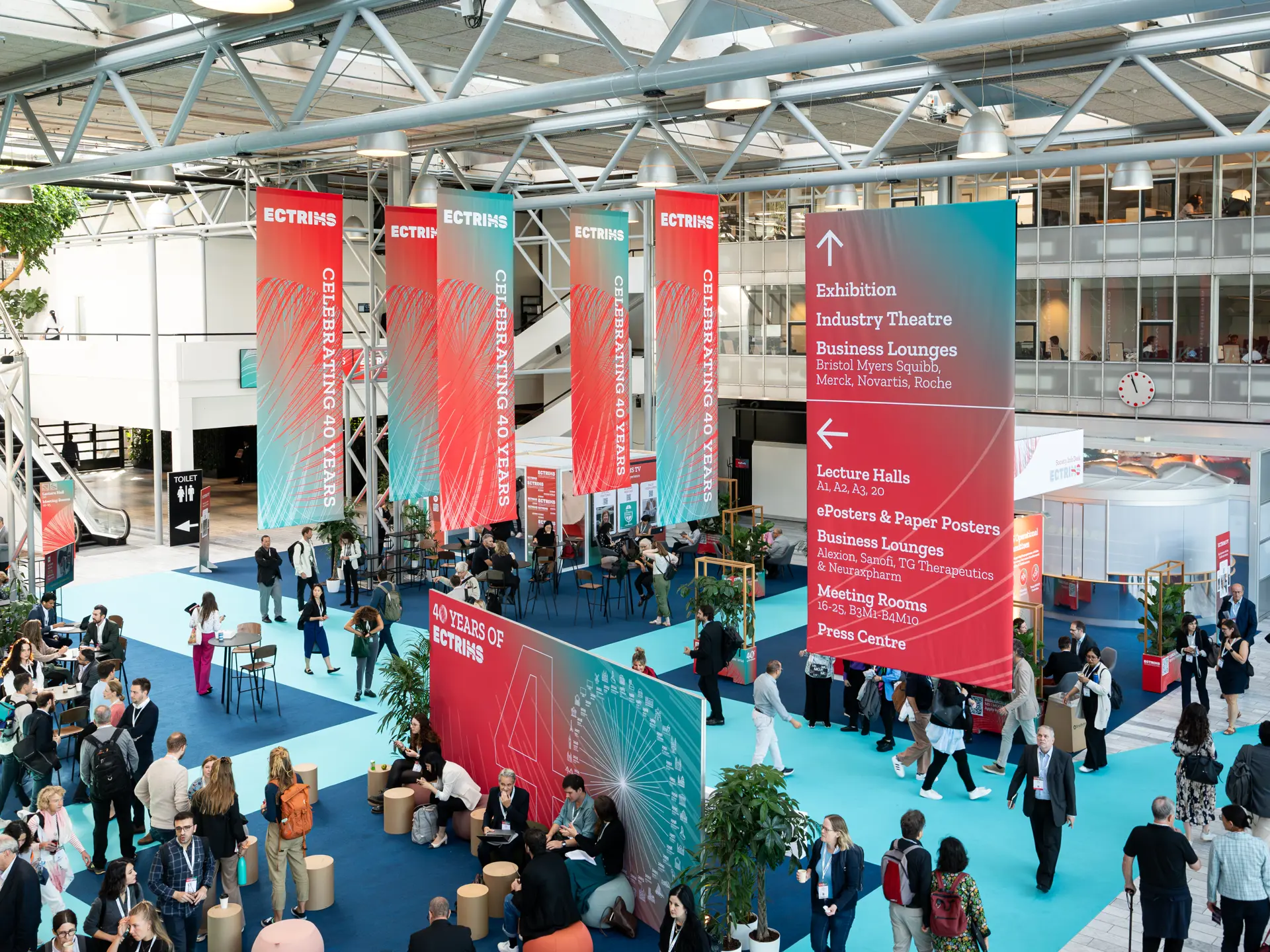 Foyer i Bella Center under ECTRIMS-konferencen med bannere og informationsstande.