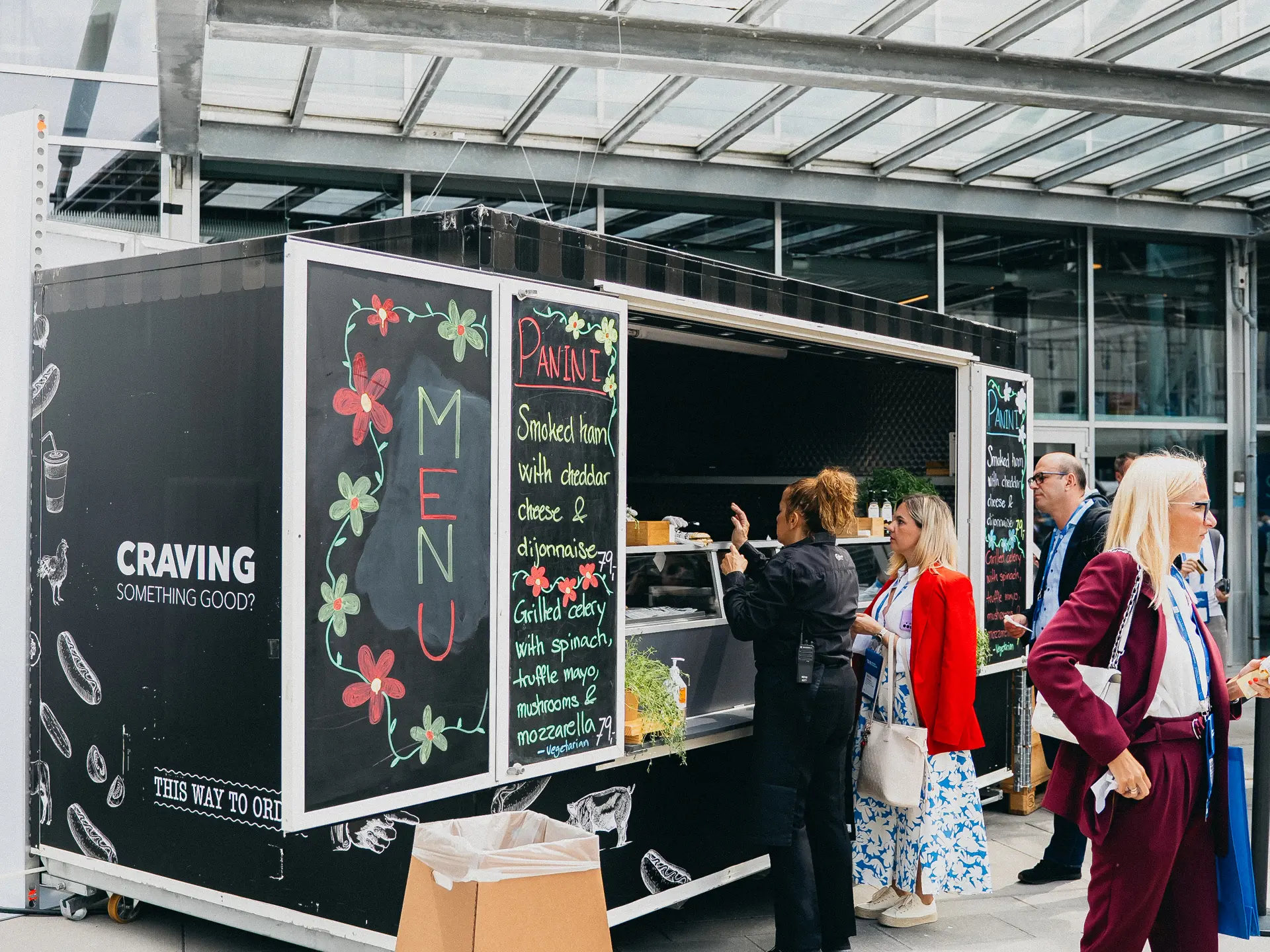 Streetfood stand med menukort og gæster foran i Bella Center.